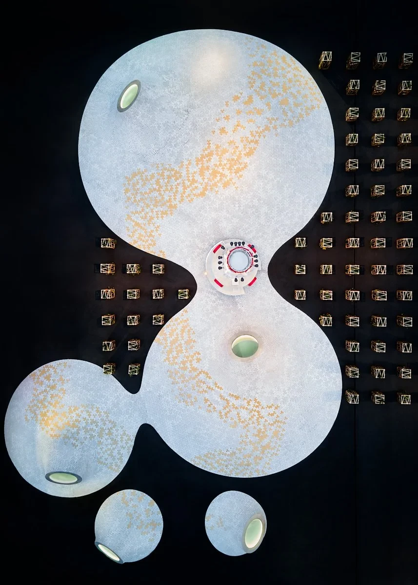 Abstract ceiling design with large circular structures and geometric patterns.